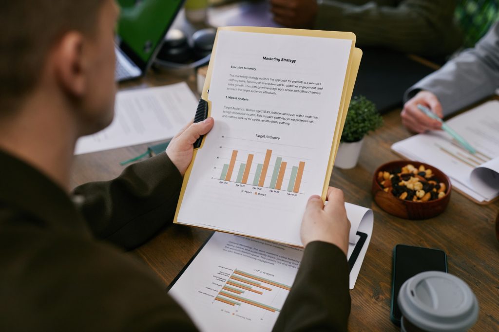 Marketing Strategy Report with Graphs Placed on Desk in Office