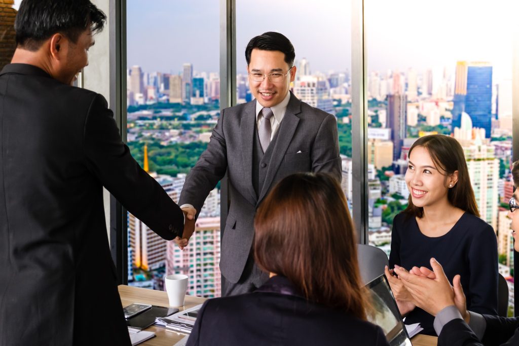Successful business team shaking hands, finishing up a meeting.